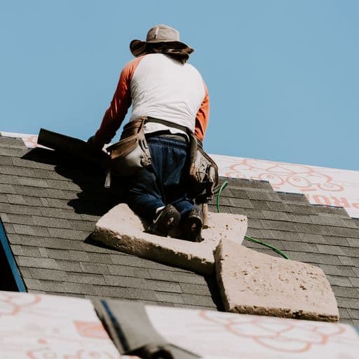 Roofer installing shingles on a roof