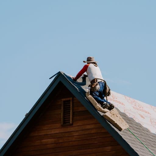Roofer working at the peak of a roof