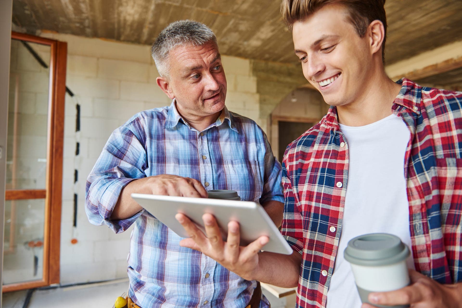Project team reviewing plans on a tablet at a job site